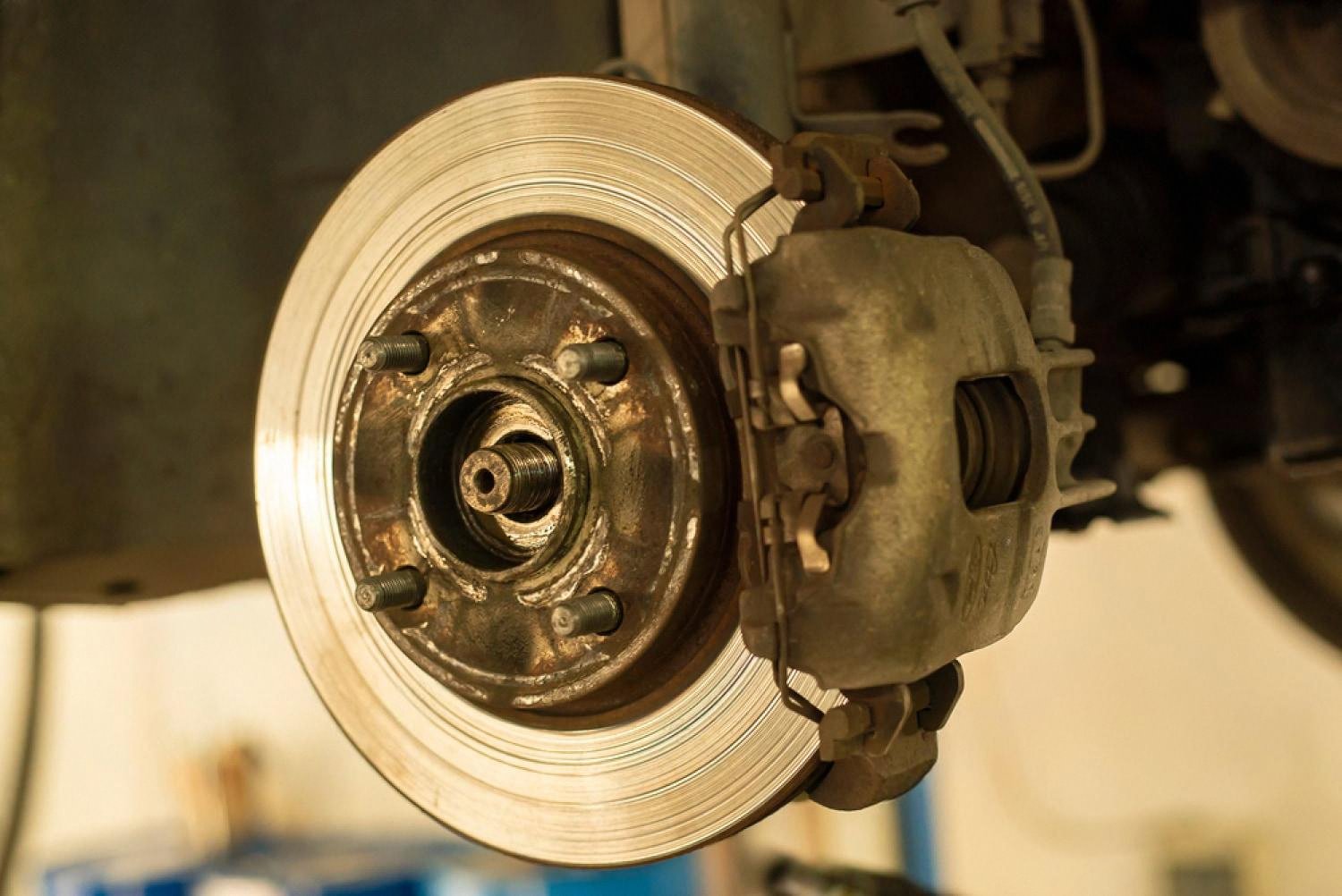 Close-up of a used car brake disc and caliper during a pre-sale mechanical inspection